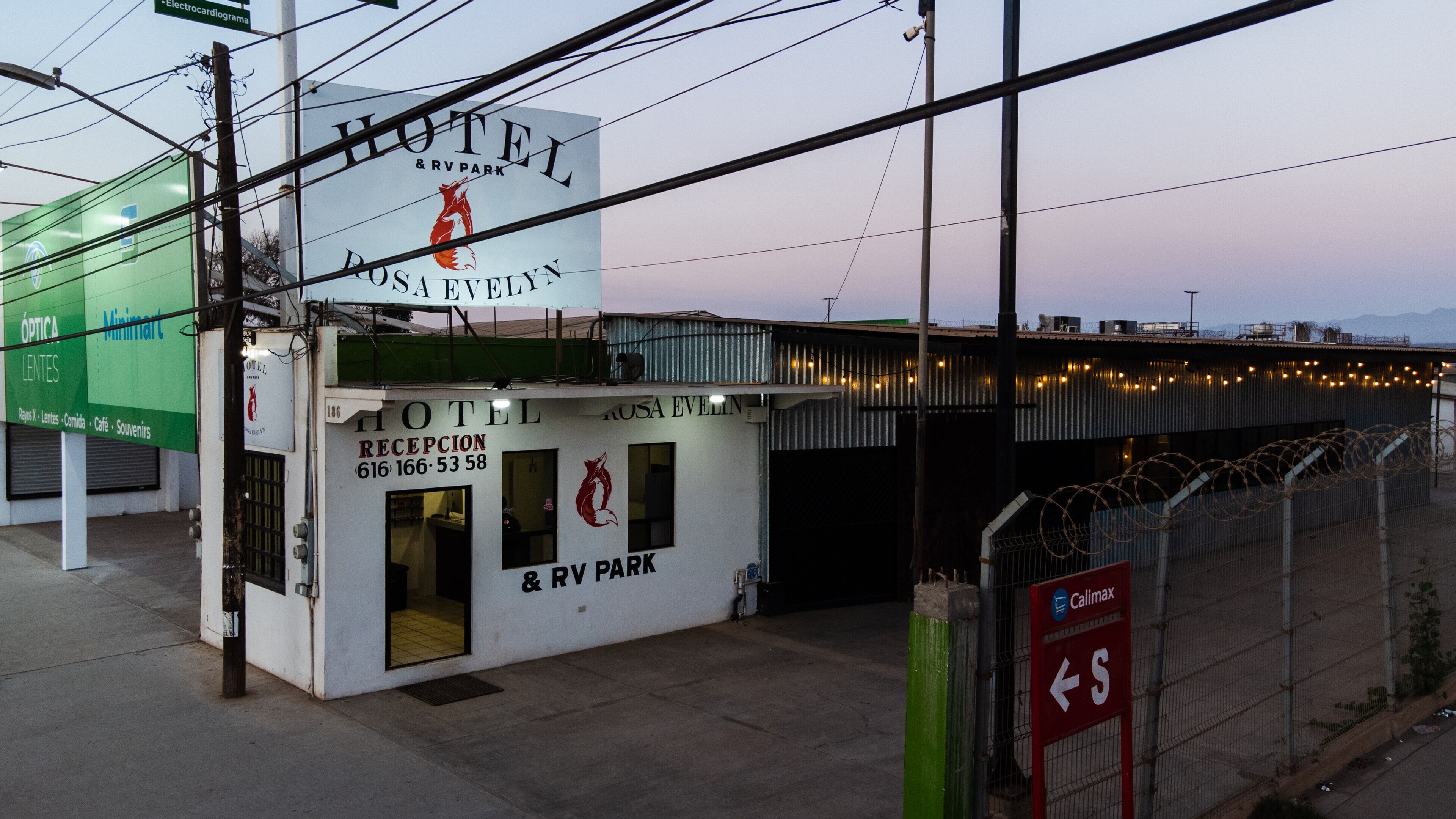 A hotel named Rosa Evelyn with a reception area, a visible phone number, and a sign indicating RV park availability.