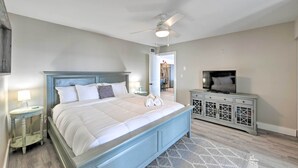 A bedroom with a bed, a ceiling fan, a TV, and a nightstand with a lamp. - Updated Waterfront Escape w/ Dock & Fire Pit (Pensacola)