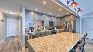 A modern kitchen with granite countertops, stainless steel appliances, and a large island. - Updated Waterfront Escape w/ Dock & Fire Pit (Pensacola)