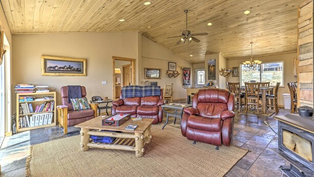 A spacious living room with leather sofas, a coffee table, and a fireplace.