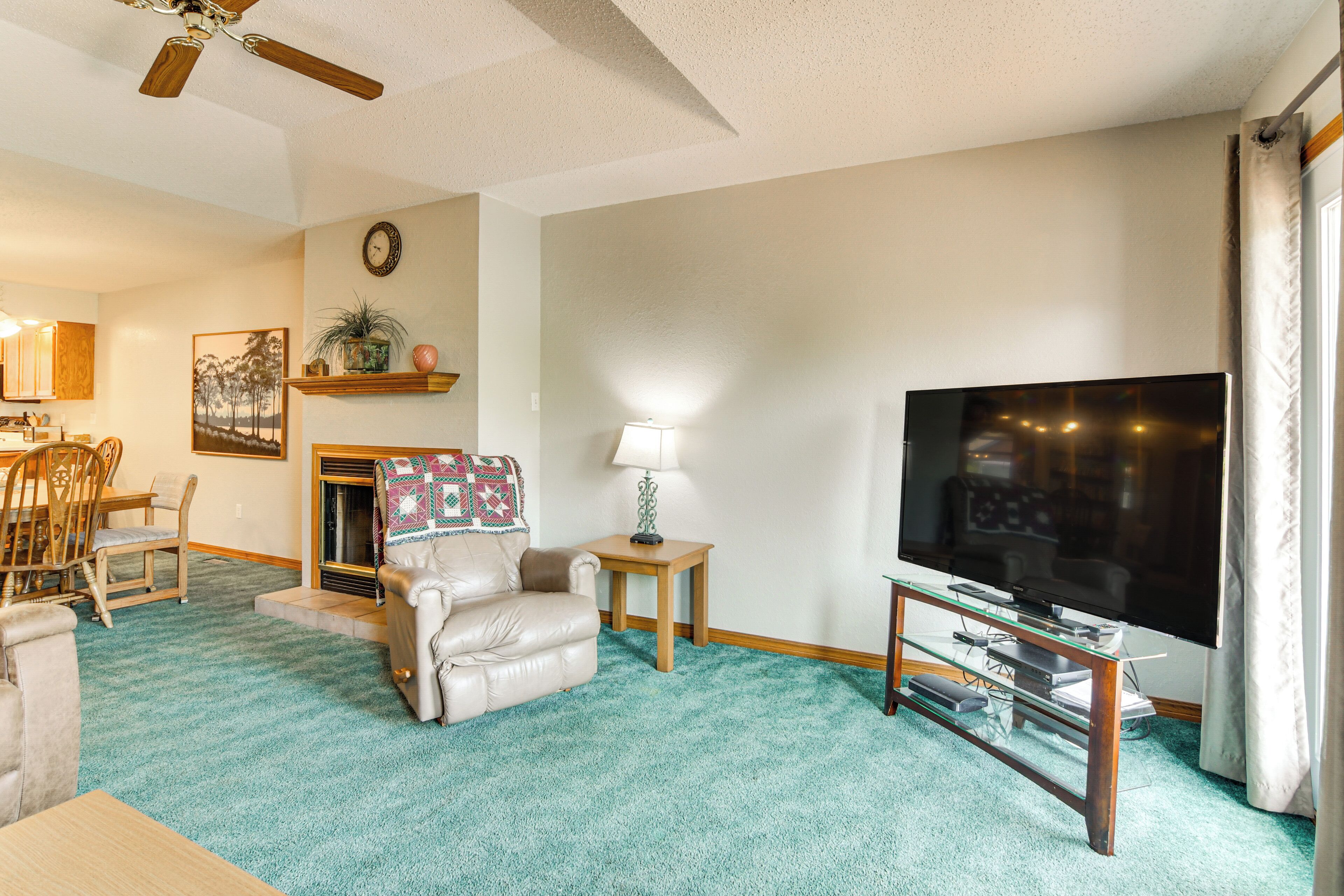 A living room with a fireplace, a television, and a dining area with chairs and a table.