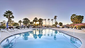 Ein Swimmingpool mit Liegestühlen und Palmen.