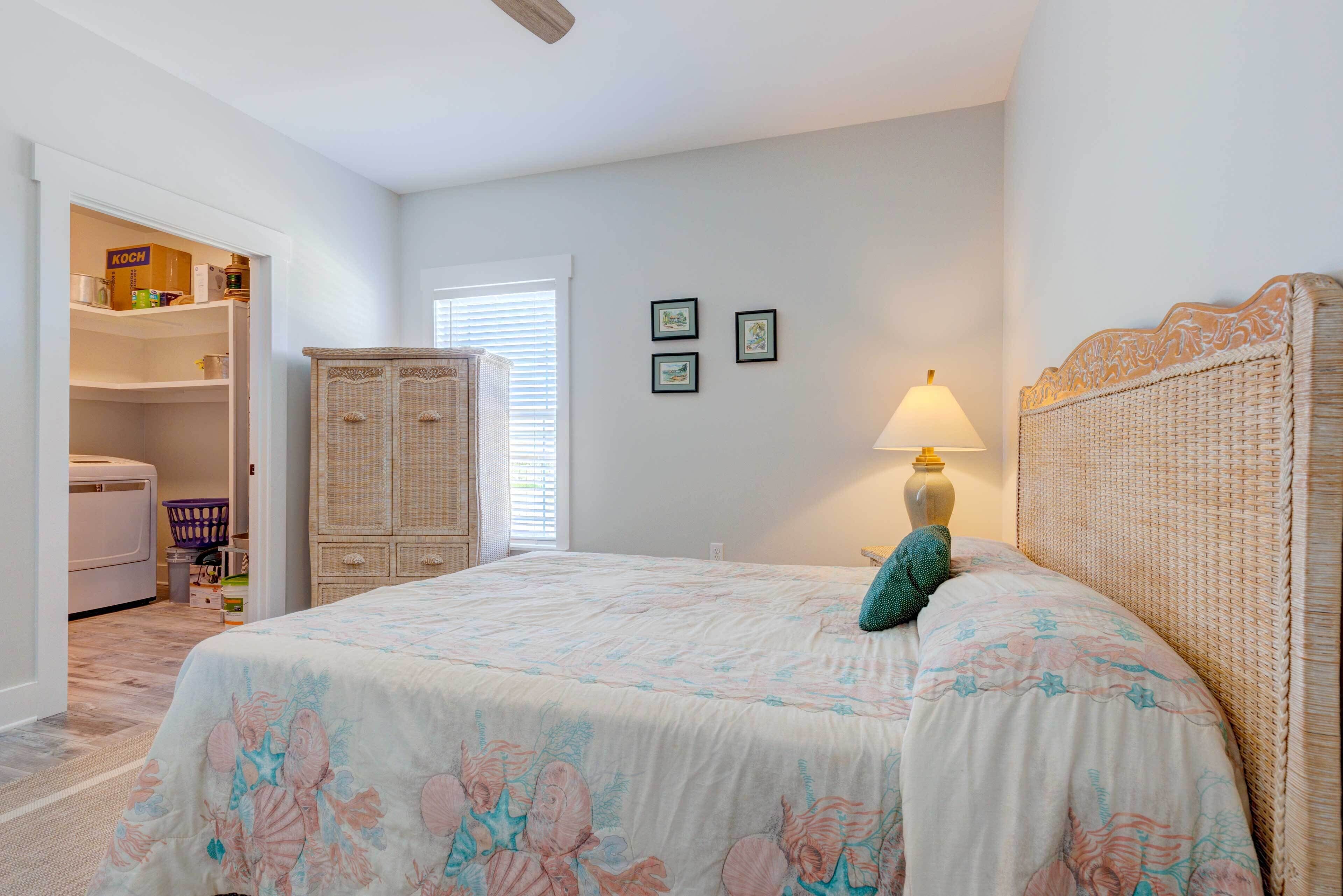 A bedroom with a bed, a wicker headboard, a lamp, and a wardrobe.