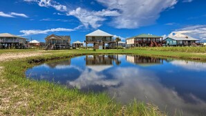 A waterfront property with multiple houses connected by walkways over water. - Bayfront Dauphin Island Home w/ Beach Access! (Dauphin Island)