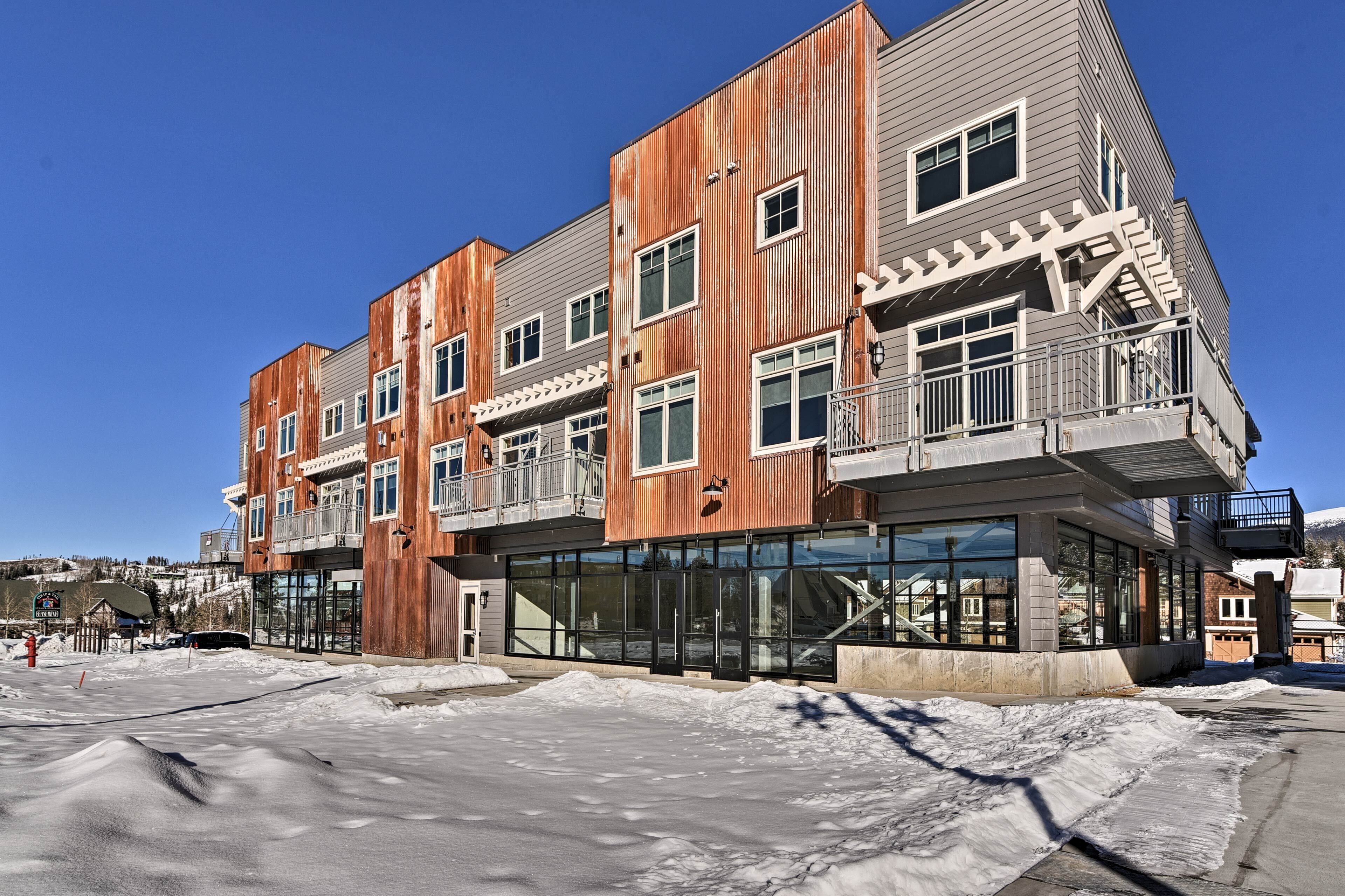 A multi-story building with a modern design, featuring large windows and a mix of wooden and metal materials.