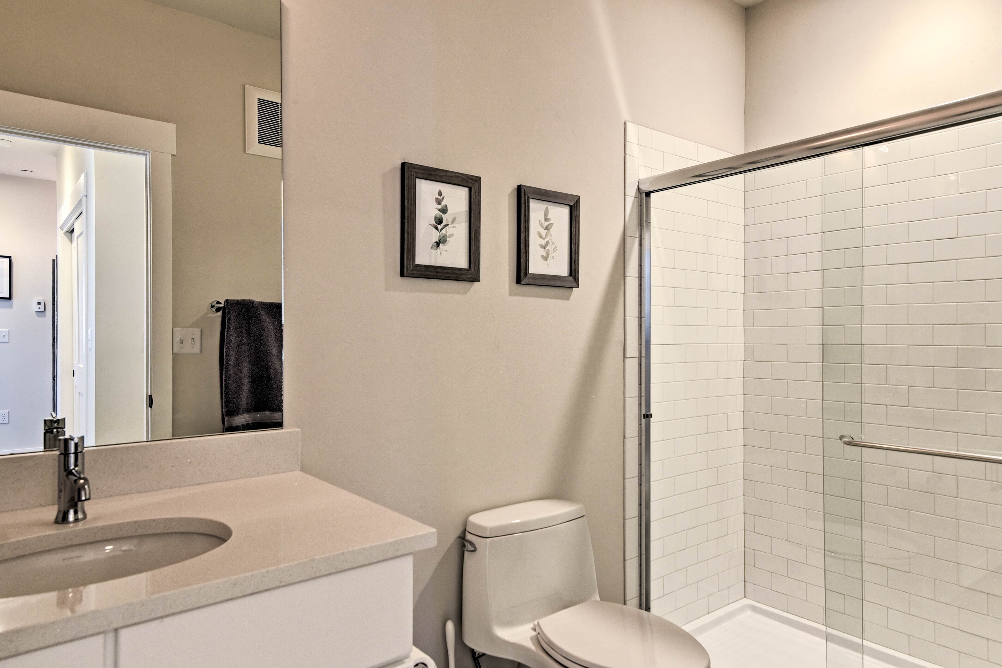 Une salle de bain équipée de toilettes, d’un lavabo et d’une douche à parois en verre.