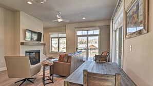 Un salón espacioso con chimenea, una gran mesa de comedor de madera y un rincón de estar acogedor.