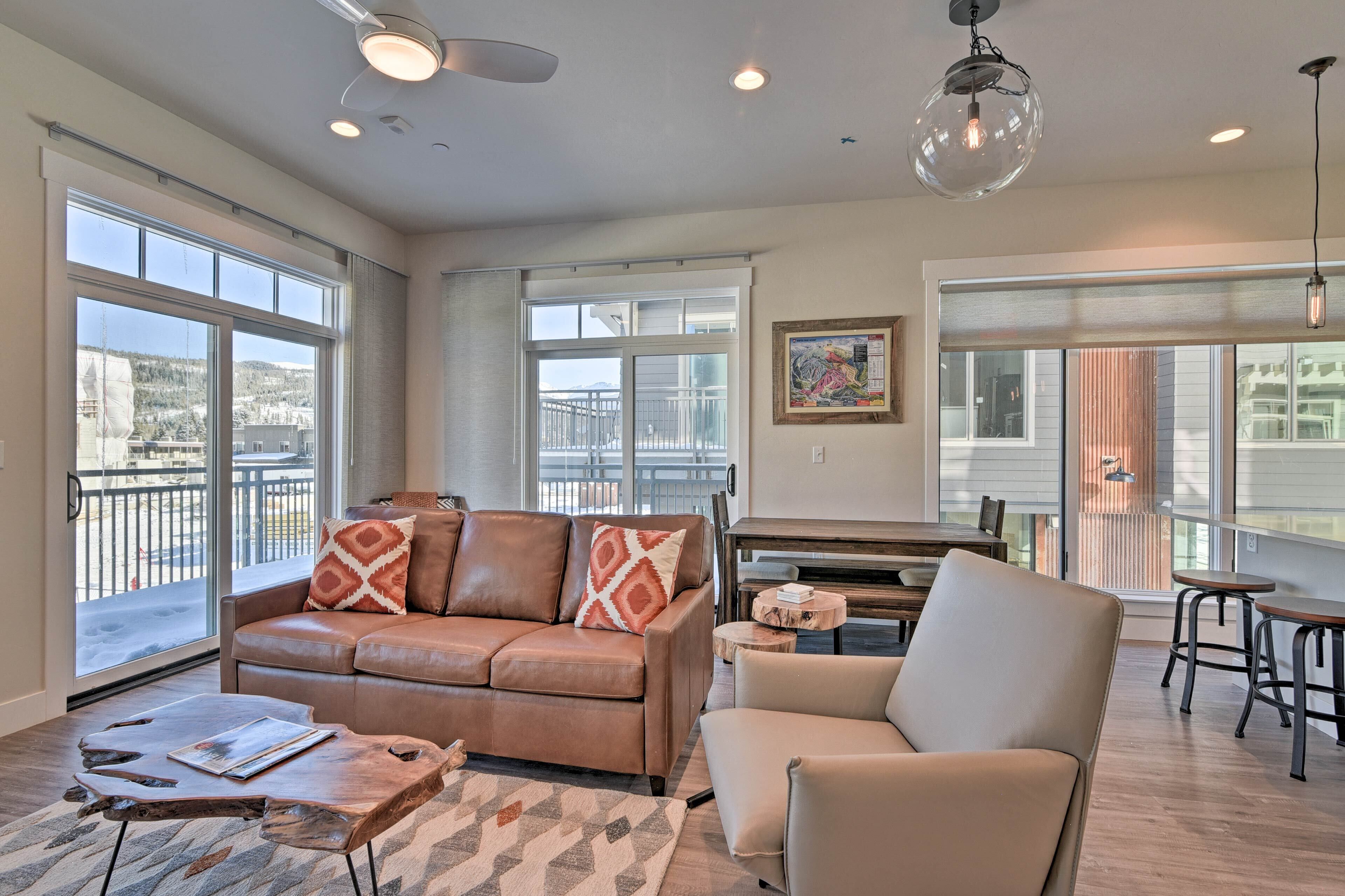 A modern living room with a leather sofa, a wooden coffee table, and a dining area with a small table and chairs.