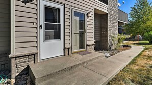 Une maison à deux étages avec une porte d’entrée, une porte de garage et un petit porche.