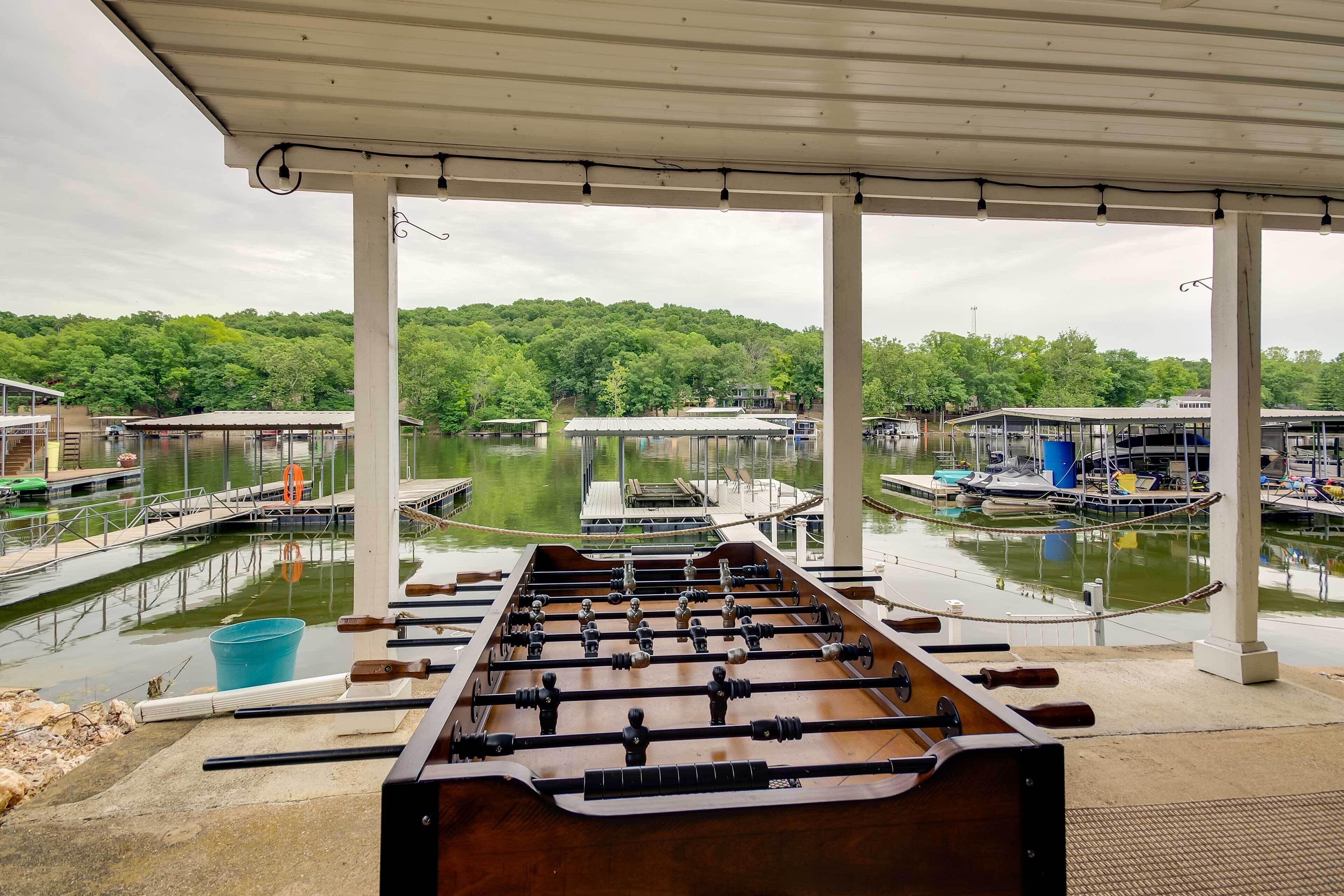 A foosball table under a covered area with a view of a marina and boats.