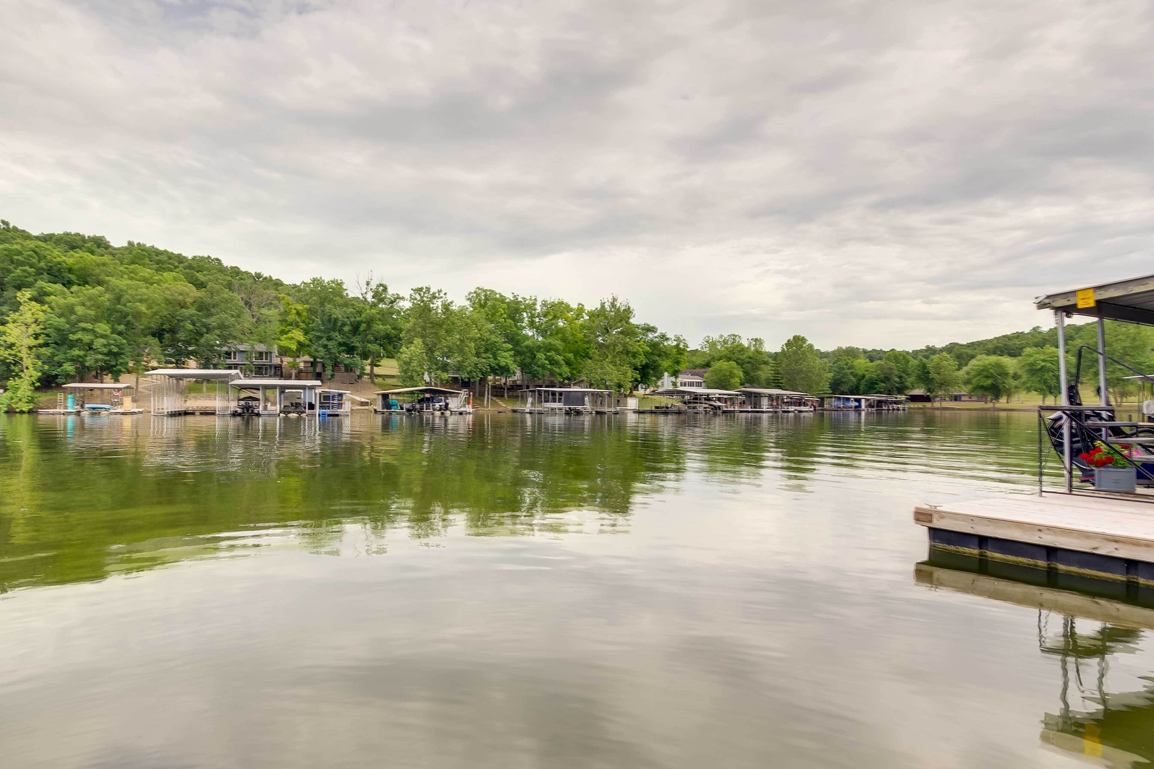 A calm lake with docked boats and a wooden pier.