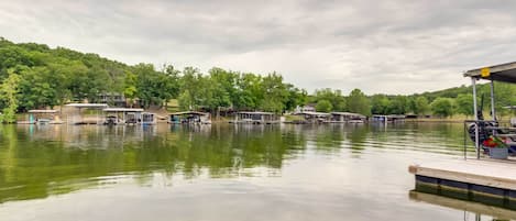 A calm lake with docked boats and a wooden pier.