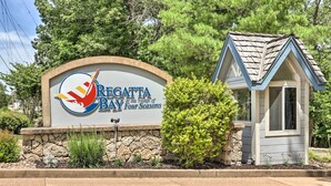 A sign for Regatta Bay at the Village of Four Seasons, with a small building and landscaping in front. - Lake-view Patio, Pool Access! Regatta Bay Condo (Lake Ozark)
