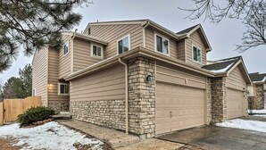 A two-story house with a stone foundation, beige siding, and a garage. - 13 Mi to Dtwn Denver: Northglenn Townhome w/ Patio (Northglenn)