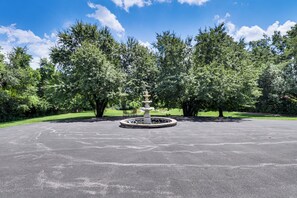 A fountain in a circular stone basin surrounded by trees in a park. - 'hidden Paradise' on 5 Acres w/ Hot Tub & Deck! (Florissant)