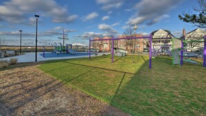 A playground with purple and green equipment, a slide, and a swing set. - Beautifully Renovated Beach House w/ Fenced Patio! (Atlantic City)