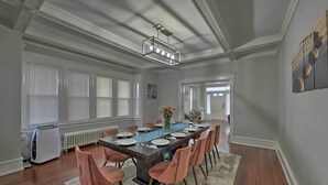 A dining area with a long table set for six, surrounded by six chairs. - Beautifully Renovated Beach House w/ Fenced Patio! (Atlantic City)