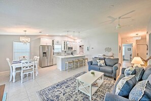 A modern living room with a dining area, kitchen, and a ceiling fan. - Retreat w/ Heated Pool Near Vanderbilt Beach! (Naples)