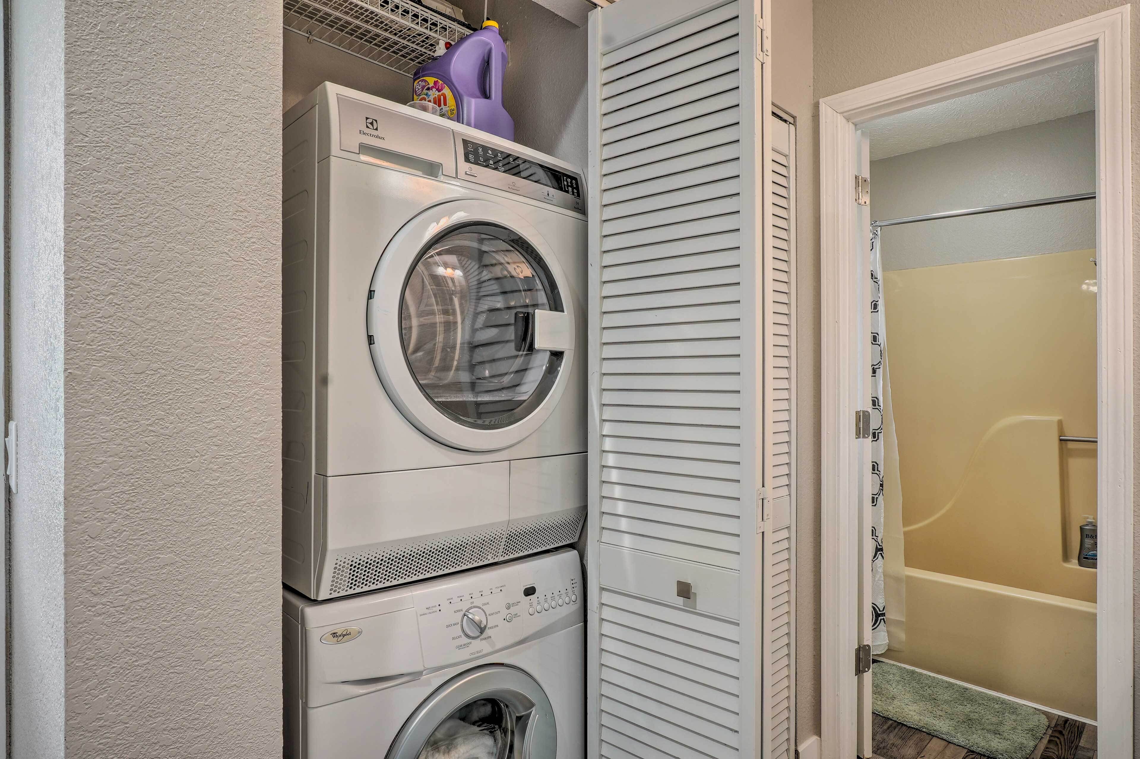 A laundry area with stacked washing machines and a shower stall.