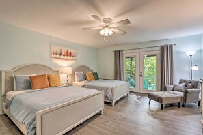 A bedroom with two beds, a ceiling fan, a chair, and a view of the outdoors. - Pools, Water Park! Margaritaville Resort Home (Osage Beach)