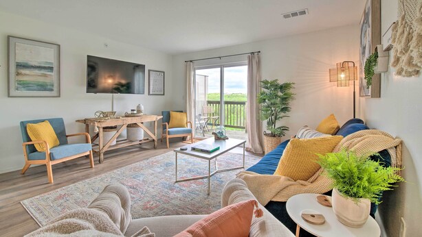 A cozy living room with a sofa, armchair, and coffee table. There is a TV mounted on the wall and a window with curtains. - Cozy Branson Retreat w/ Balcony, 2 Mi to 76 Strip (Branson)