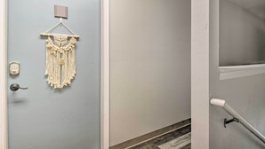 A door with a macrame wall hanging, a doorbell, and a door handle. - Cozy Branson Retreat w/ Balcony, 2 Mi to 76 Strip (Branson)