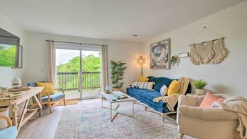 A cozy living room with a sofa, coffee table, and a dining area with a table and chairs.