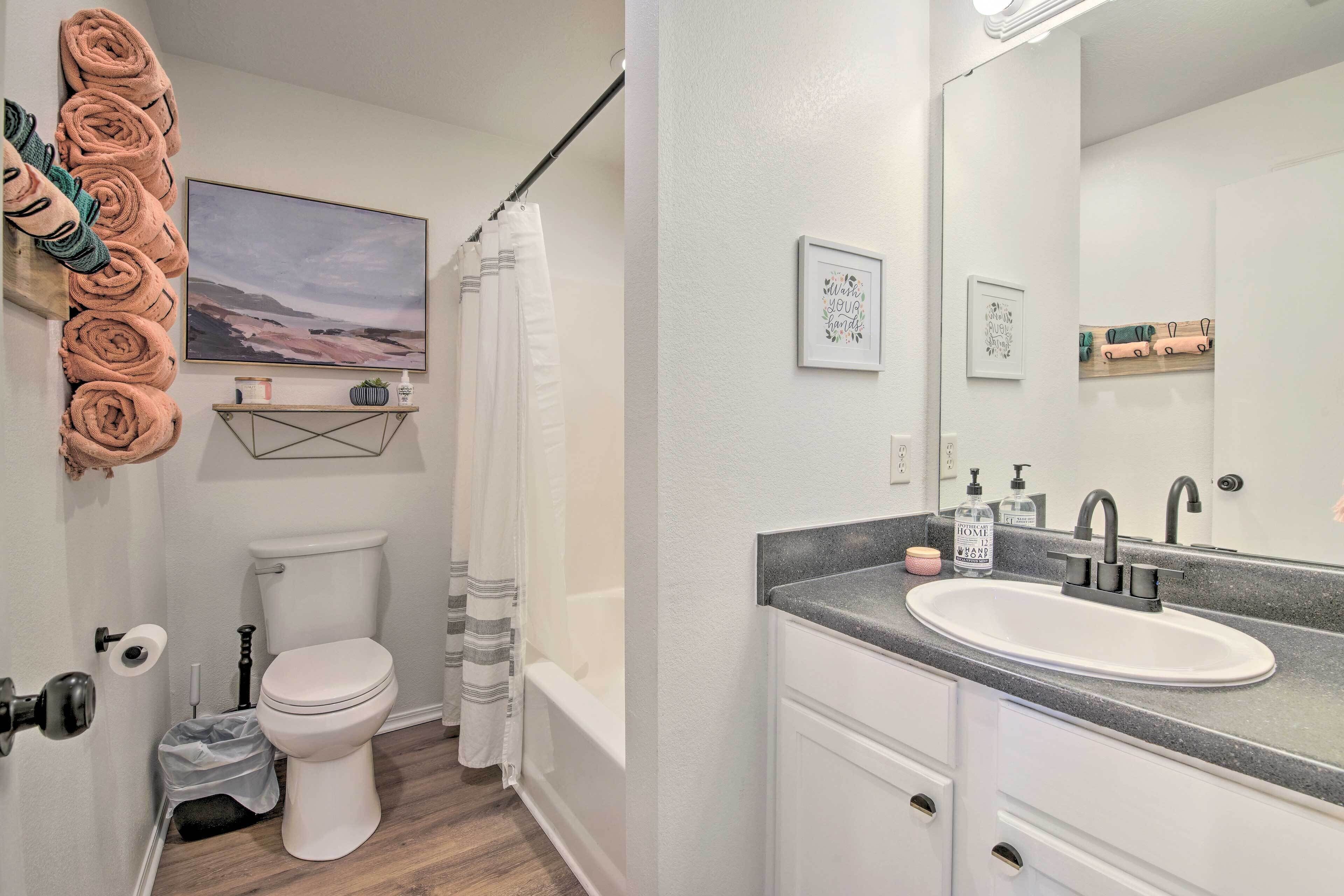 A bathroom with a toilet, sink, and shower curtain.