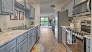A modern kitchen with grey cabinets, stainless steel appliances, and a marble countertop. - Cozy Branson Retreat w/ Balcony, 2 Mi to 76 Strip (Branson)