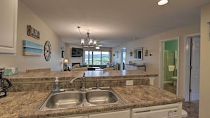 A modern kitchen with granite countertops, a double sink, and a central island. - 'the Lake Escape w/ Balcony & Pool Access! (Camdenton)