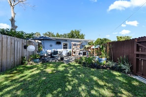 A backyard with a patio, outdoor furniture, and a wooden fence. - Swim, Golf & Relax: Beach Apt w/ Private Yard! (Jacksonville Beach)