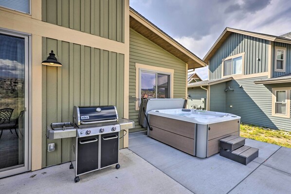 A backyard with a grill, hot tub, and a sliding door leading to a patio. - Updated Mtn Home ~ 6 Mi to Winter Park Resort (Fraser)