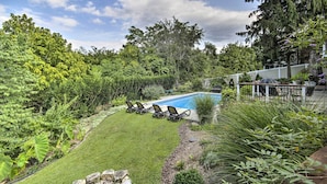 A backyard with a swimming pool, surrounded by lush greenery and a patio area with outdoor furniture. - Harpers Ferry Apartment w/ Private Pool & Hot Tub! (Harpers Ferry)