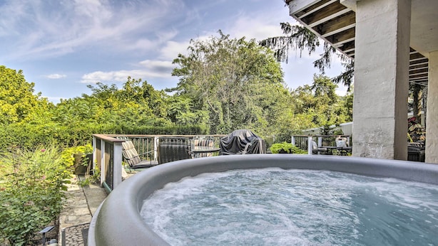 An outdoor hot tub surrounded by lush greenery and a covered patio area. - Harpers Ferry Apartment w/ Private Pool & Hot Tub! (Harpers Ferry)