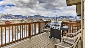 A deck with a grill, chairs, and a view of snow-covered mountains. - 11 Mi to Keystone: Silverthorne Condo w/ Deck (Silverthorne)