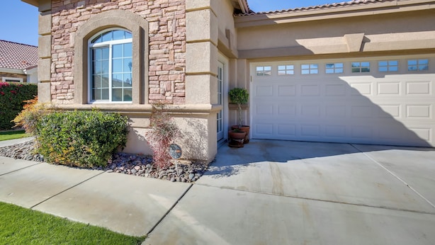 A residential house with a stone facade, a large arched window, and a garage. - Indio Casita: 2 Mi to Coachella & Stage Coach! (Indio)