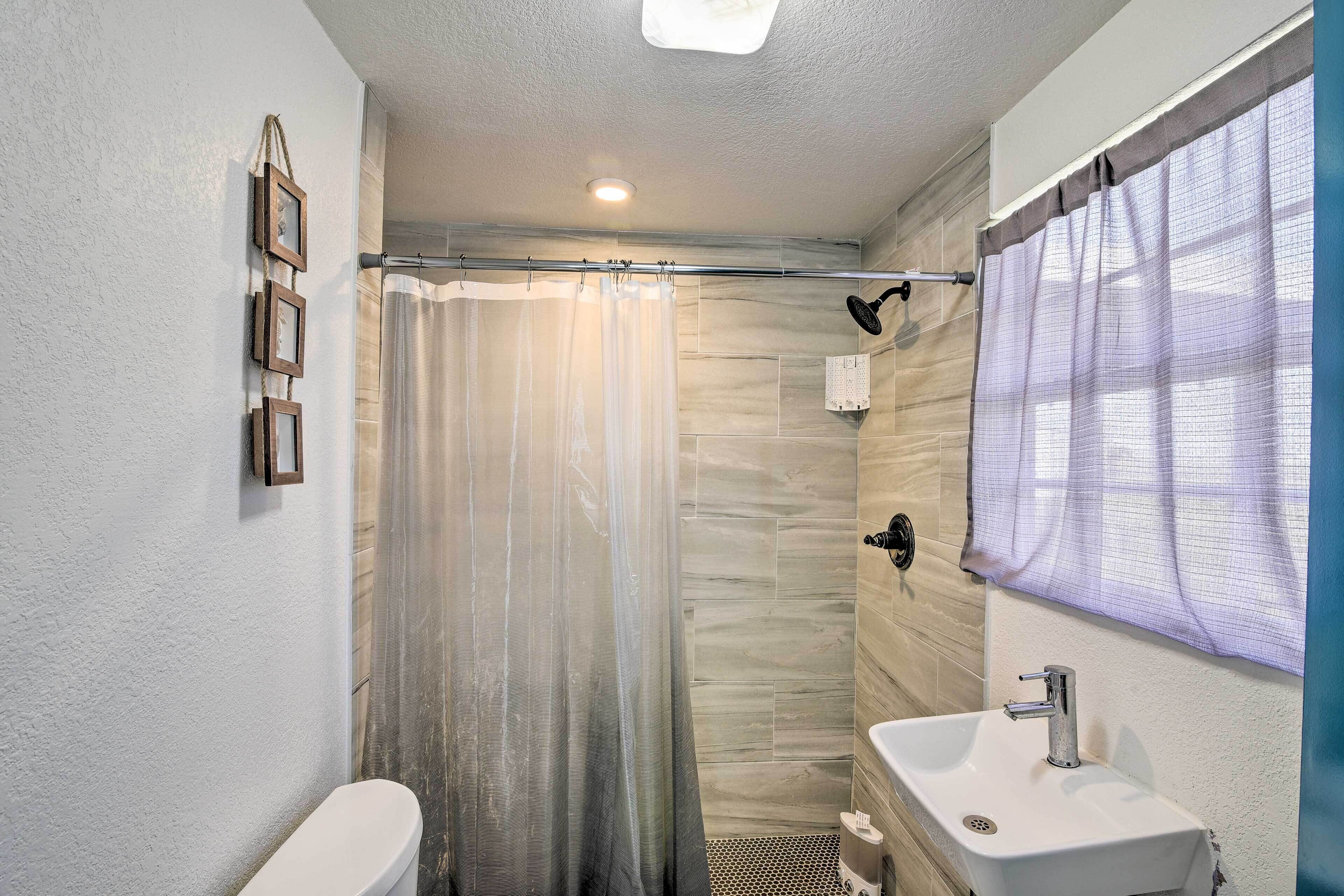 A bathroom with a shower, toilet, and sink.