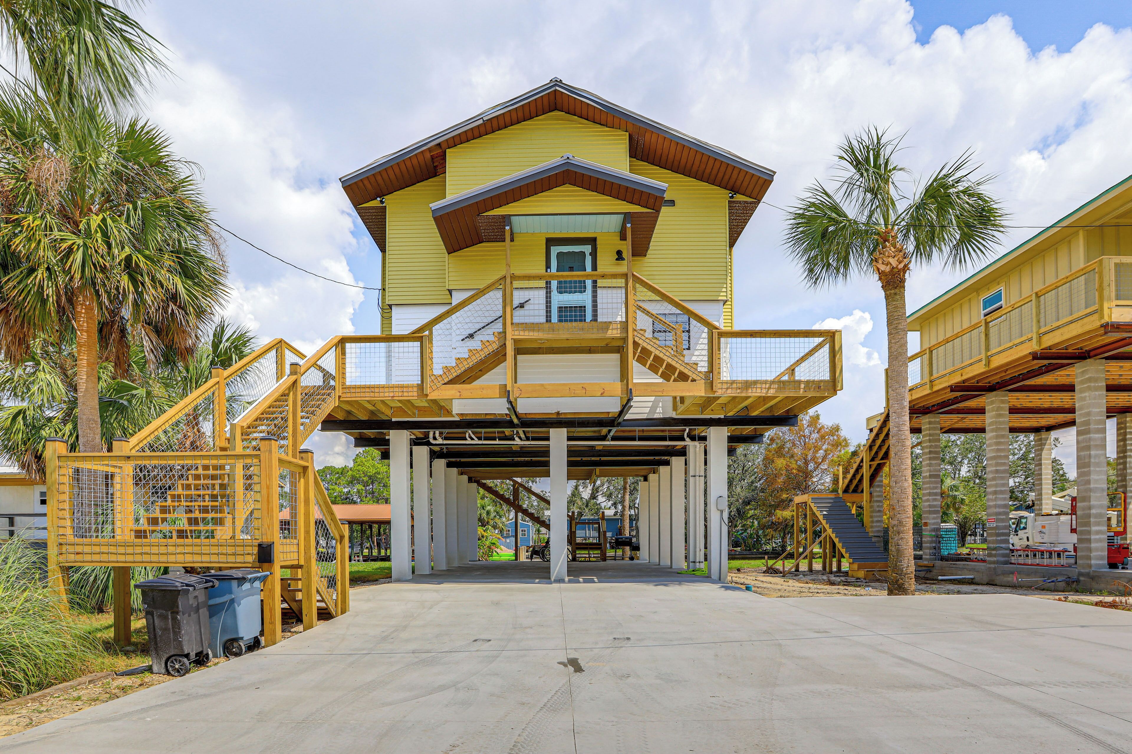 A yellow building with a covered entrance and a staircase leading to a balcony.
