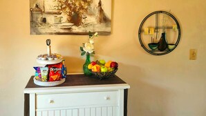 A kitchen counter with a jar of Doritos, a vase with flowers, and a fruit bowl. - Near Red Rocks, Hiking & Skiing: Kittredge Condo! (Kittredge)