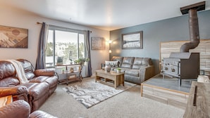 A cozy living room with leather sofas, a fireplace, and a view of the outdoors. - Near Red Rocks, Hiking & Skiing: Kittredge Condo! (Kittredge)