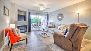A living room with a sofa, armchair, and a fireplace. - Screened Balcony w/ Views: Sleek Lake Ozark Gem! (Lake Ozark)