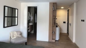 A modern bedroom with a bed, a bedside table, a chair, a wardrobe, and a mirror. - Trendy Loft in Güemes - Walk to Art, Bars & Antiques (Unquillo asociacion civil corral de barrancas)
