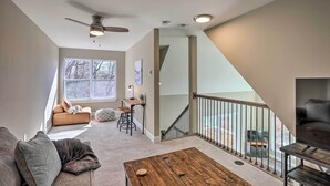 A spacious living area with a sofa, coffee table, and a staircase leading to an upper level.