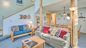 A cozy living room with a wooden staircase, a blue sofa, a grey sofa, and a wooden coffee table. - 6 Mi to Turquoise Lake: Retreat w/ Covered Deck! (Leadville)