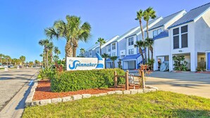 A hotel named 'The Spinnaker' with a sign, palm trees, and a well-maintained lawn. - Padre Island Retreat on Canal - 2 Mi to Beach! (Corpus Christi)