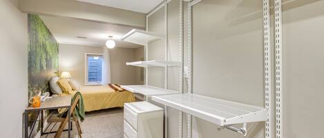 A compact bedroom with a bed, a desk, and a wardrobe.