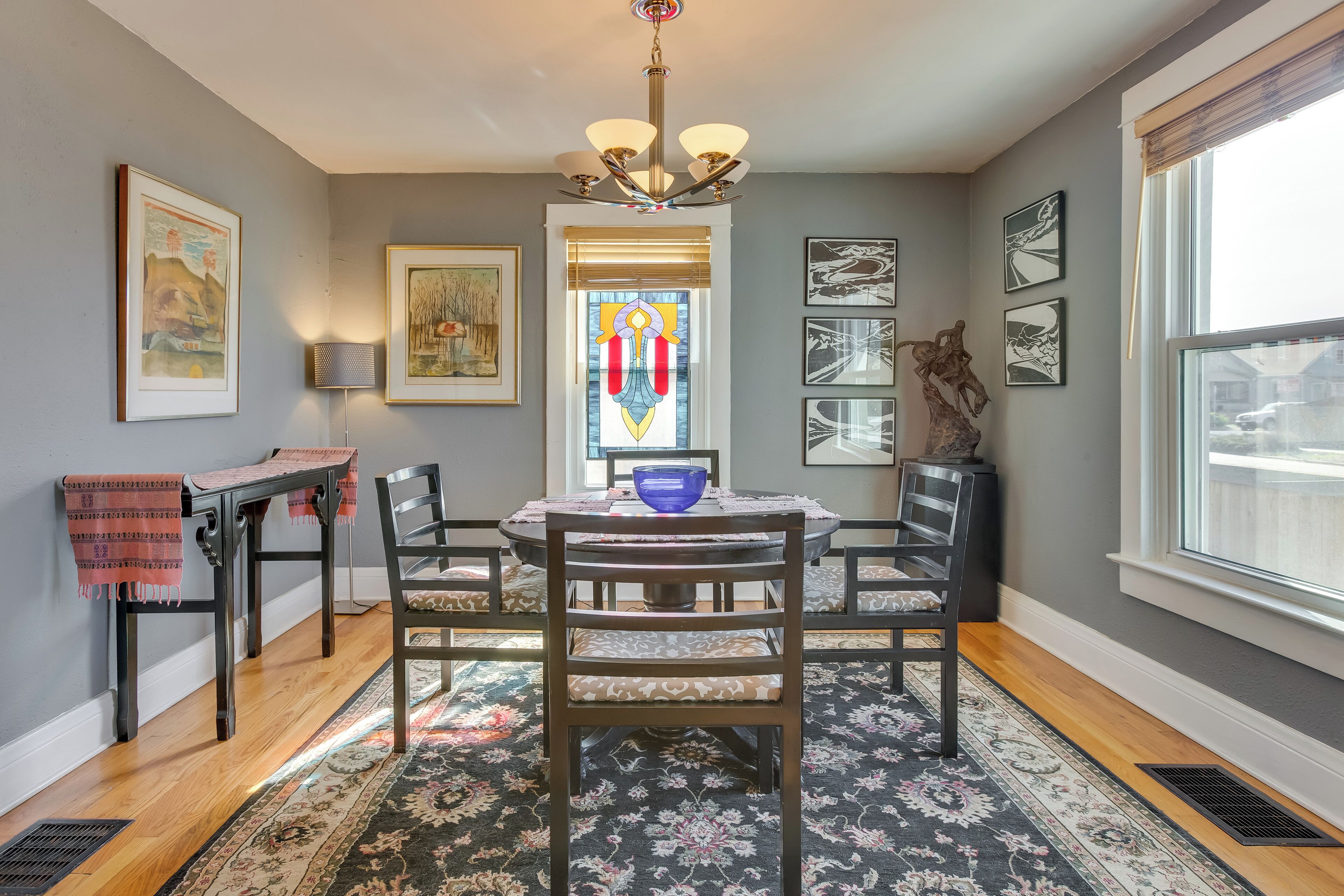 A dining area with a table, chairs, and a chandelier.