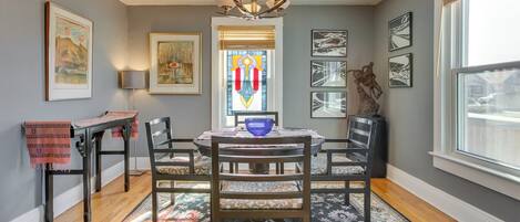 A dining area with a table, chairs, and a chandelier.