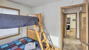A room with a bunk bed, a wooden ladder, a colorful quilt, and a window with blinds. - Cozy Oshkosh Home, 4 Blocks to Lake Winnebago (Oshkosh)