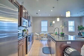 A modern kitchen with stainless steel appliances, a central island, and pendant lighting. - Updated Fiesta Isles Condo w/ Bay Views & Pool! (South Padre Island)
